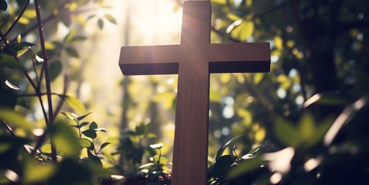 Ein Holzkreuz in der Natur, umgeben von Licht.